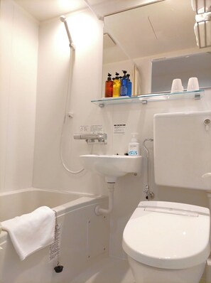 Bathroom features a bathtub, sink, and toilet, with a shelf for toiletries.