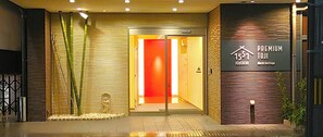 Welcome to Premium Toji, a hotel within the IcoIocoChi World Heritage, featuring a modern entrance with a glass door and bamboo elements.