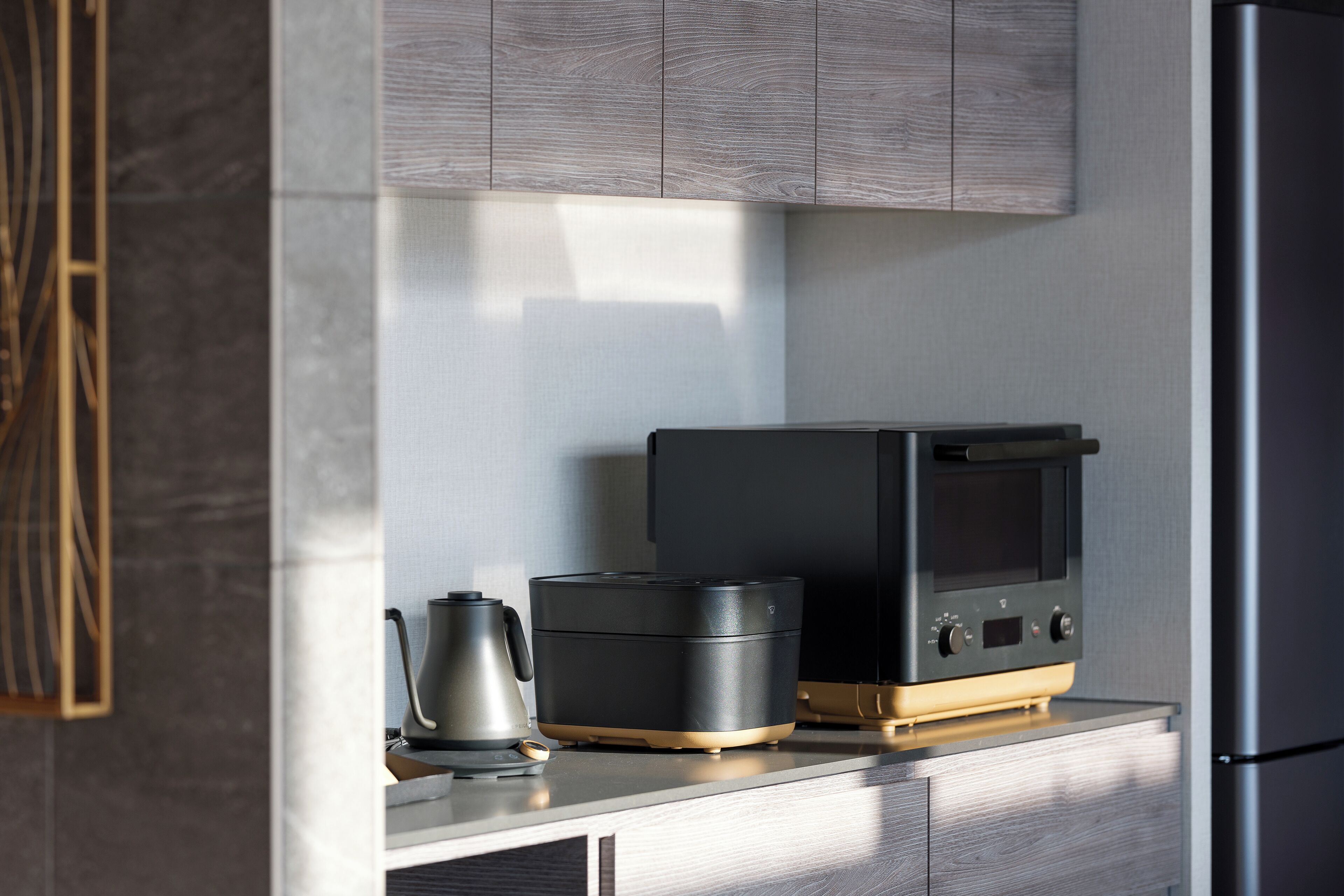 Una cocina moderna con horno empotrado, cafetera y refrigerador de acero inoxidable.