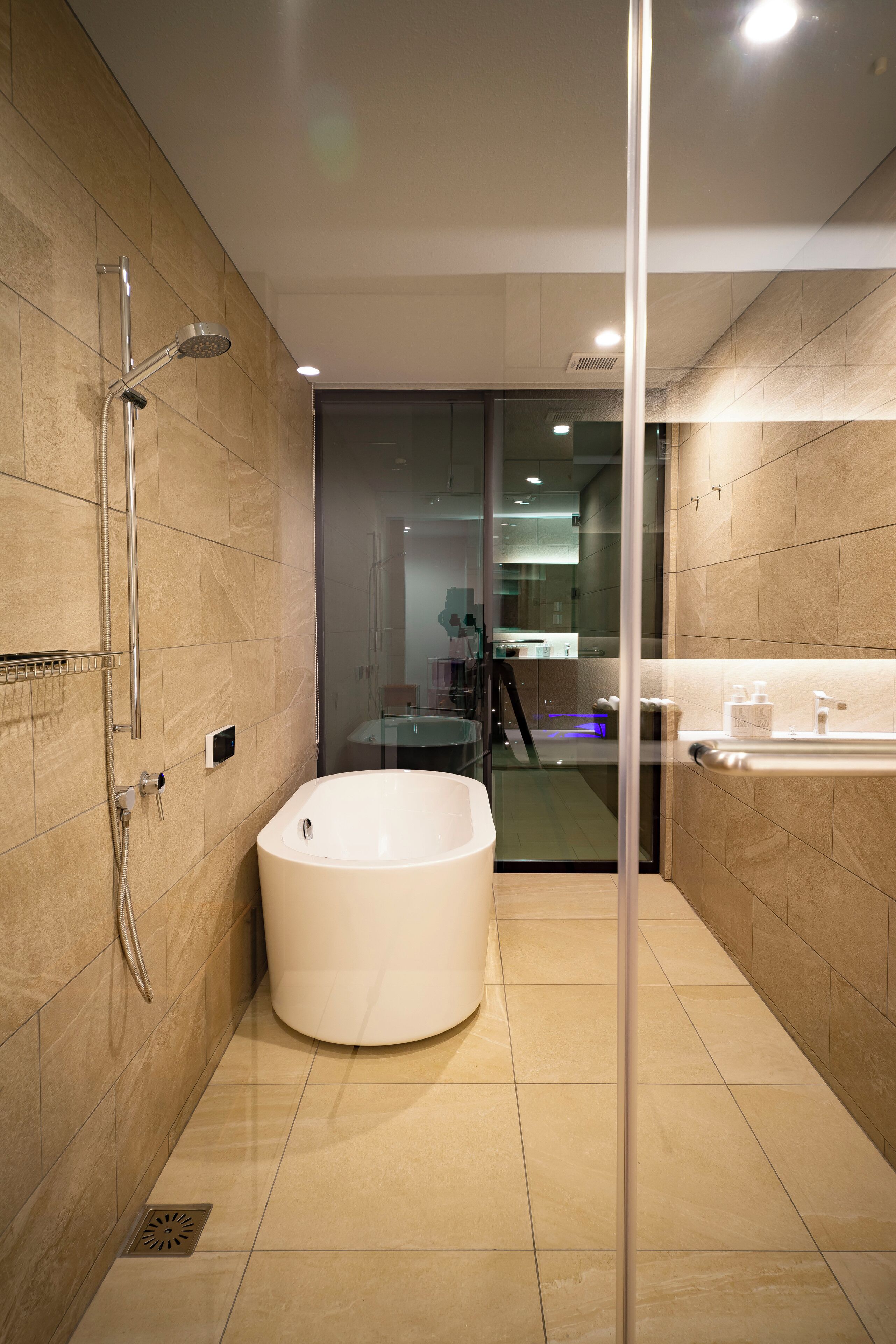 A modern bathroom with a freestanding bathtub, a glass shower enclosure, and a visible bathroom counter with a sink and mirror.