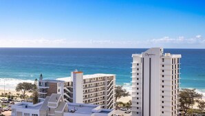 A coastal hotel with multiple floors, a prominent "Sunflower" sign, and a view of the ocean. - Ocean View Surfers Paradise Studio Suite (Surfers Paradise)