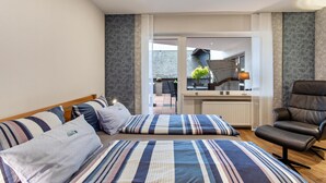 A bedroom with a bed, a chair, a window, and a view of the outside. - Haus Schönblick - Apartment 5 with Mountain View, Private Terrace and Wi-Fi (Willingen (Upland))