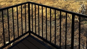 Een terras met uitzicht op een bergachtig landschap.