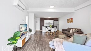 Un appartement moderne comprenant un salon, un coin repas et une cuisine.