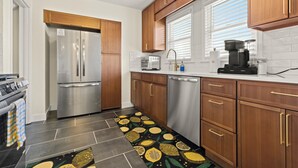 Eine moderne Küche mit Edelstahlgeräten, Holzschränken und einem gemusterten Teppichläufer.