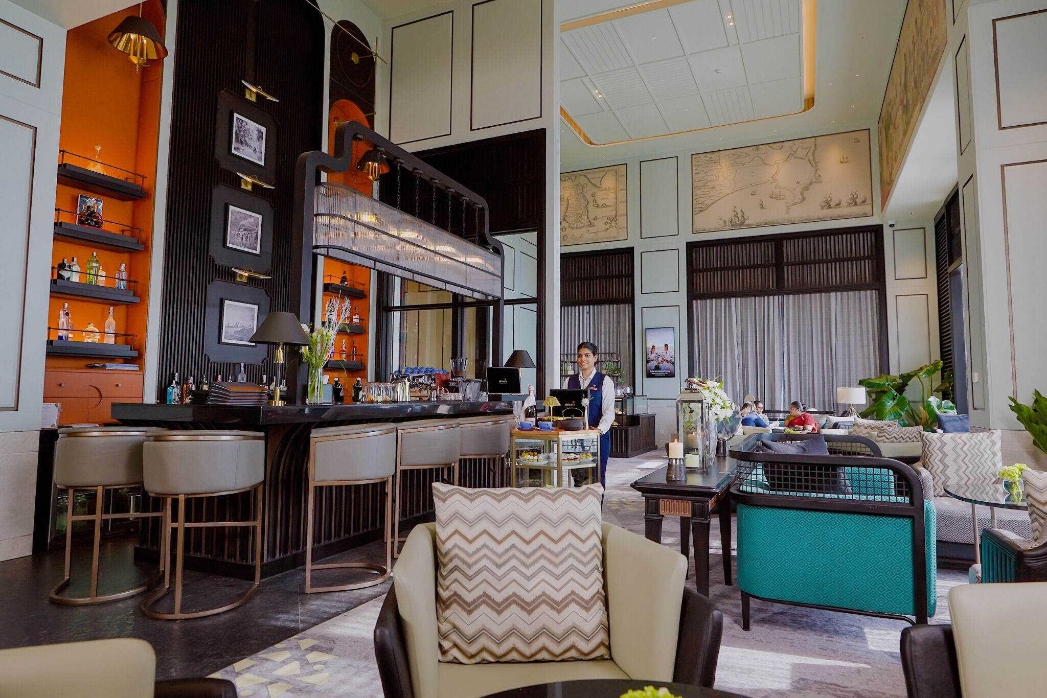 A modern hotel lobby with a bar area, seating, and a large map on the wall.