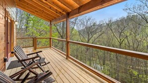 Eine Holzterrasse mit Blick auf einen Wald.