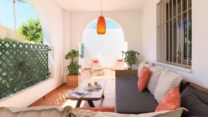 A cozy patio area with a sofa, two chairs, a table with drinks, and potted plants. - Privilegio de Marbella near Puerto Banus (Marbella)