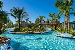 A swimming pool area with palm trees, a slide, and a fenced area. - NEW Home Storeylake 4Bd 3 Walking Clubhouse (Kissimmee)