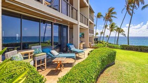 A modern hotel with a balcony overlooking the ocean, furnished with lounge chairs and tables. - Poipu Makai Villas C1 – Oceanfront, A/C, PBAC Included (Koloa)