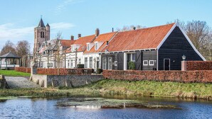 Une ville européenne traditionnelle, avec un canal, des bâtiments historiques et un clocher d’église.