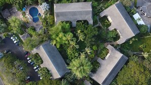 An aerial view of a resort with multiple buildings, a swimming pool, and lush greenery. - Waikomo Stream Villas 103 – Ground Floor, Garden View Retreat (Koloa)
