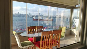 A dining area with a view of a city skyline and a river. - Cozy 2-bedroom apartment with Stunning Sea Views in enchanting Üsküdar, İstanbul (Üsküdar, İstanbul)