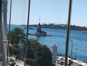 A view of a coastal city with a prominent lighthouse and a busy harbor. - Cozy 2-bedroom apartment with Stunning Sea Views in enchanting Üsküdar, İstanbul (Üsküdar, İstanbul)