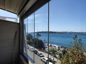 A view from a window overlooking a busy street with cars and a body of water. - Cozy 2-bedroom apartment with Stunning Sea Views in enchanting Üsküdar, İstanbul (Üsküdar, İstanbul)