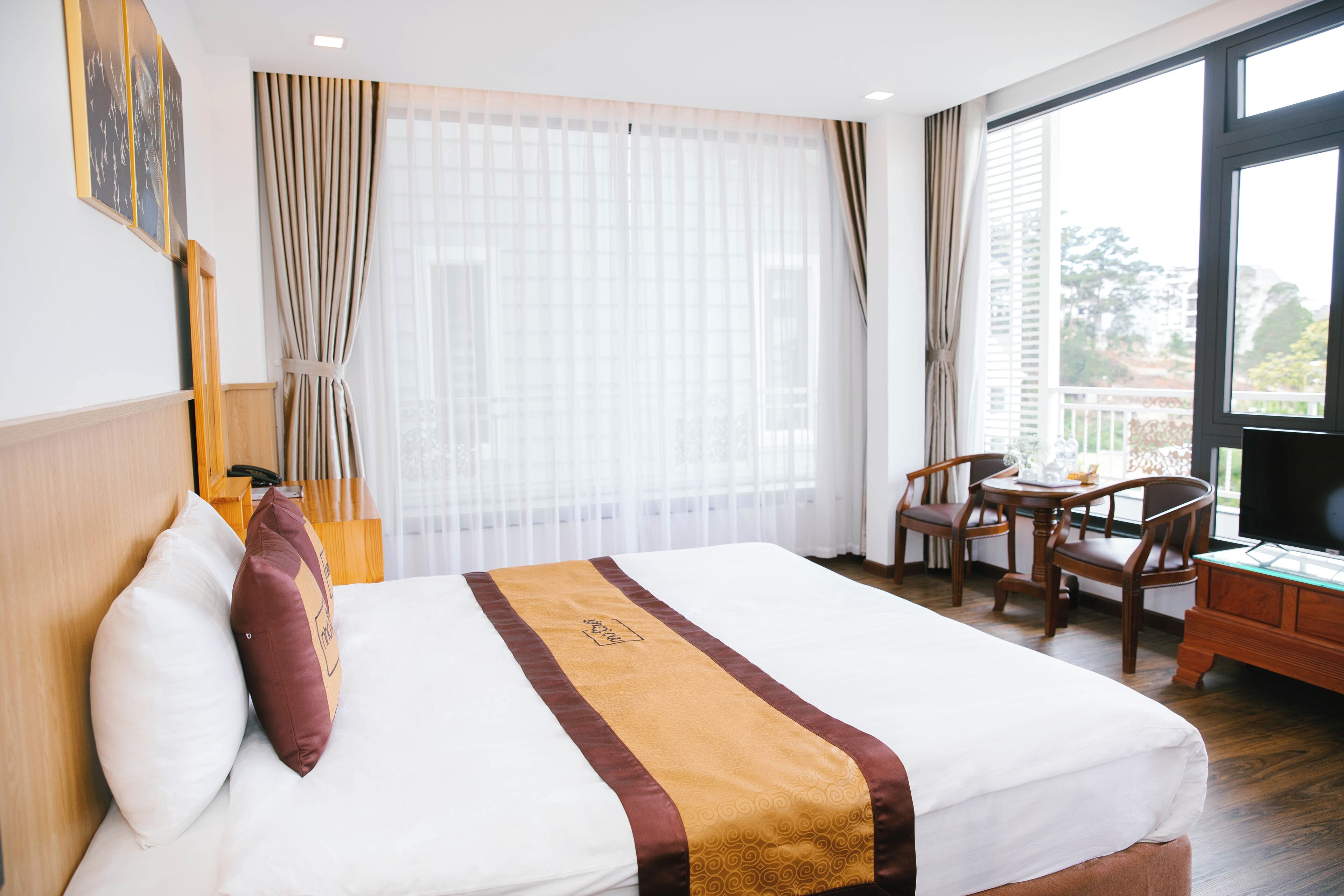 A hotel room with a bed, a desk, and a chair.