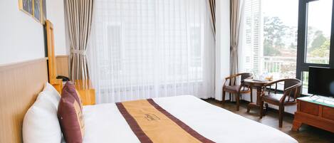 A hotel room with a bed, a desk, and a chair.