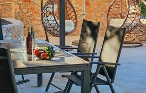 A dining area with a table, chairs, and a fruit bowl. - Amazing home in Postira (Postira)