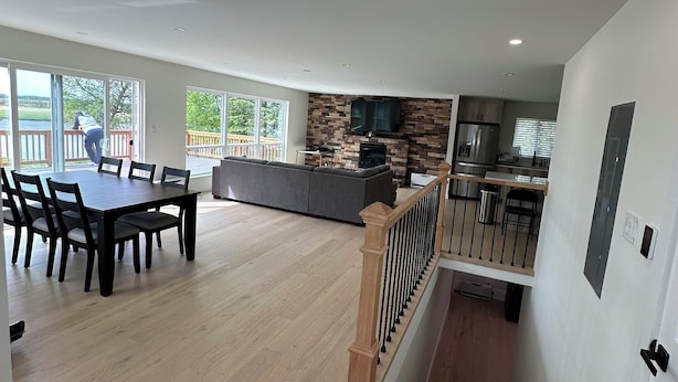 Un amplio salón con mesa de comedor, chimenea y zona de cocina.