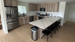 Una cocina moderna con una isla central, electrodomésticos de acero inoxidable y armarios de madera.