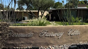 A landscaped area with a sign reading "Bermuda Fairway Villas".