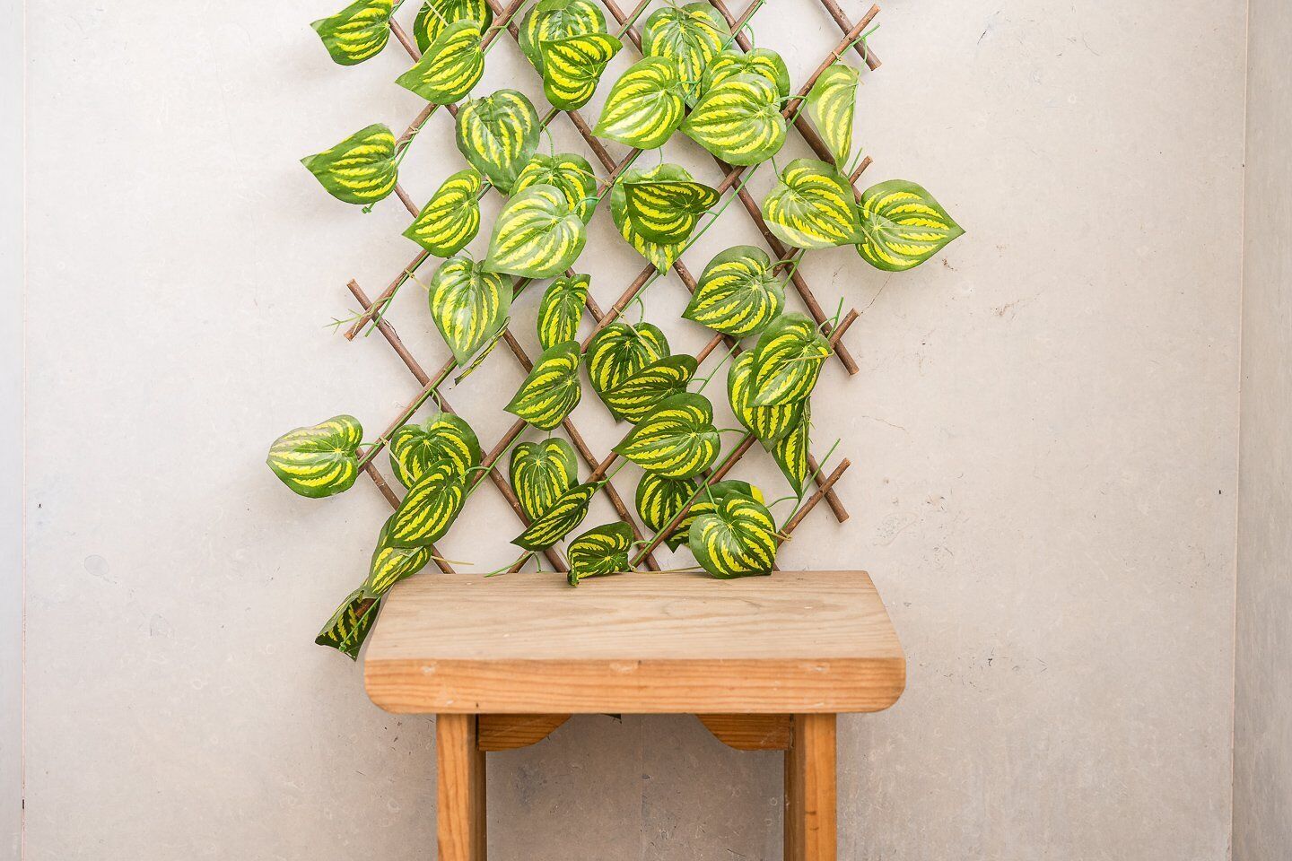 Een houten tafel met een verticale plantenwand erachter.