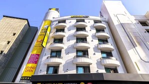 A hotel with a modern design, featuring multiple balconies and a prominent yellow sign indicating a grand opening. - BRIGHTEN HOTEL (Jeonju)