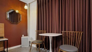 A room with a round table and two chairs, a mirror on the wall, and a curtain. - BRIGHTEN HOTEL (Jeonju)