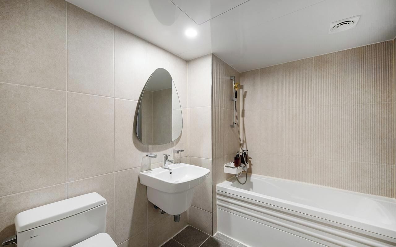 Un baño moderno con inodoro, lavamanos y bañera.