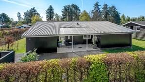 Un bâtiment moderne avec un toit en métal, un patio couvert et le chiffre « 15 » peint sur le côté.