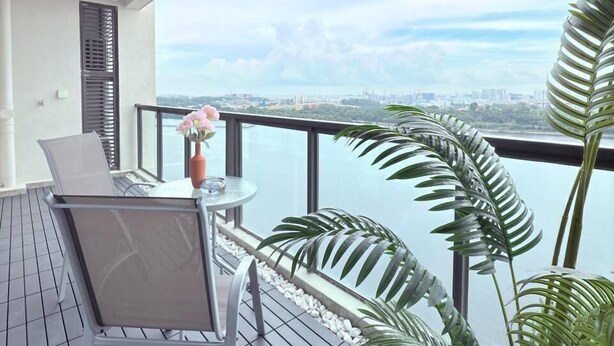Un balcón con una mesa y sillas, con vistas a un paisaje urbano.