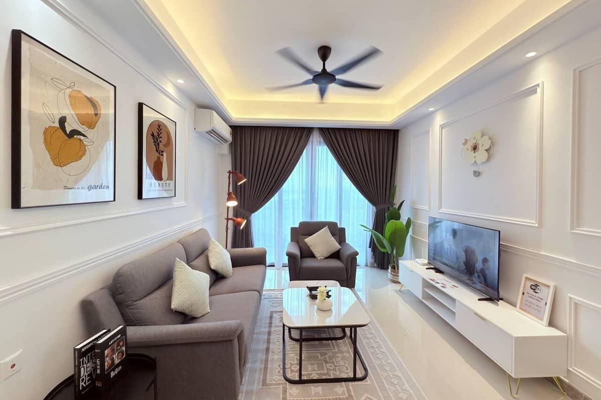 A modern living room with a sofa, armchair, coffee table, and TV.