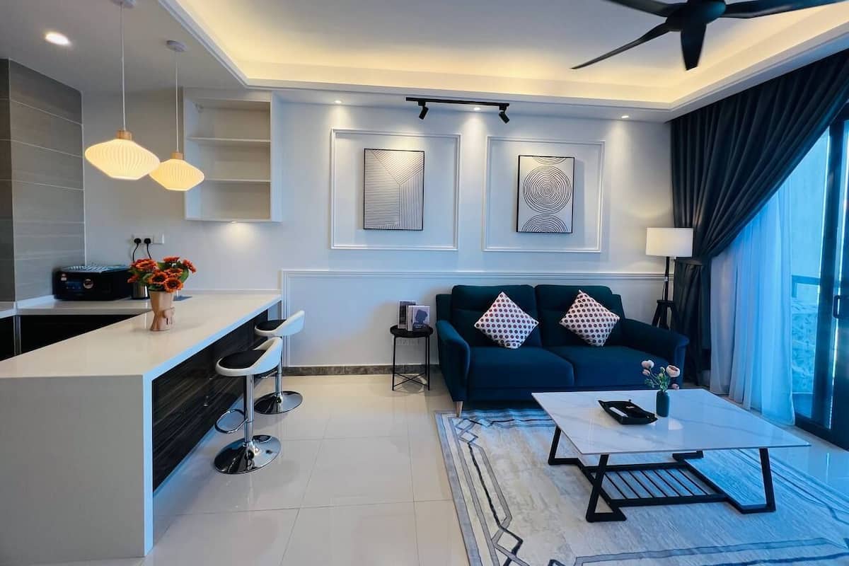 A modern living room with a sofa, coffee table, and bar area.