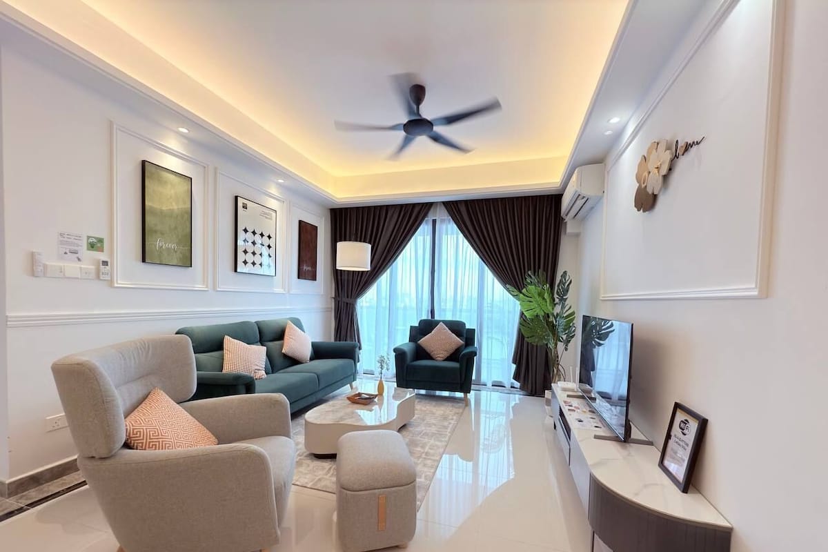 A modern living room with a sofa, armchair, coffee table, and a TV.