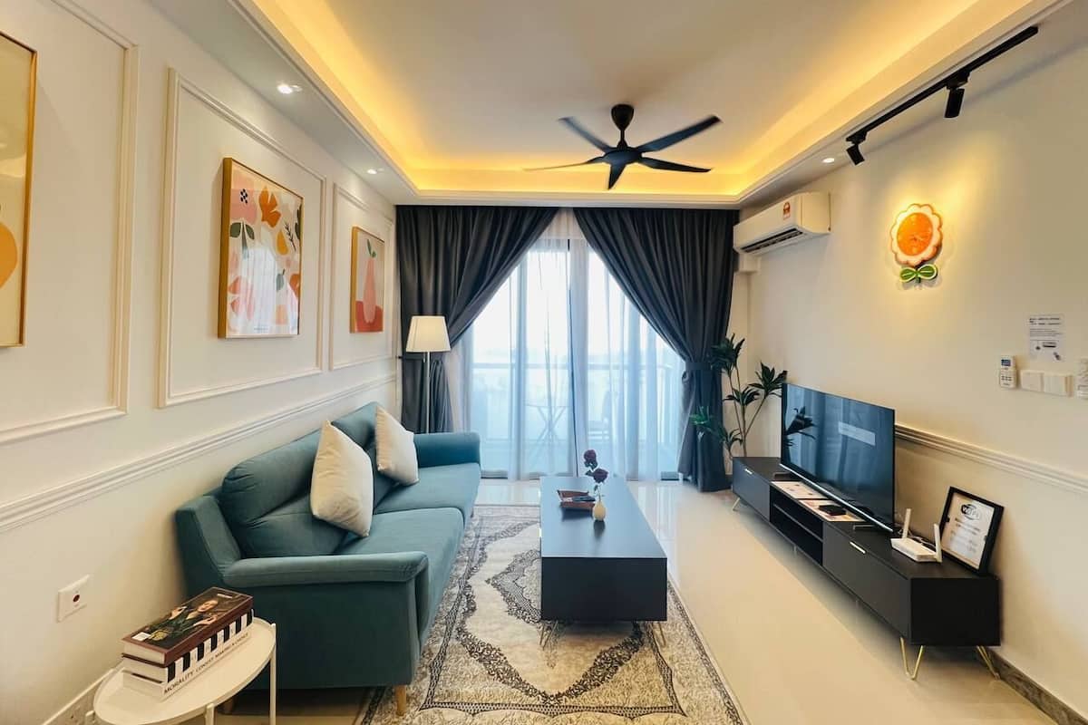 A modern living room with a sofa, coffee table, TV, and artwork on the walls.