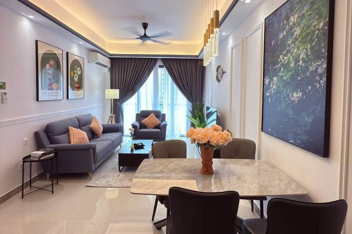 A modern living room with a dining area, featuring a sofa, coffee table, and a dining table with chairs.