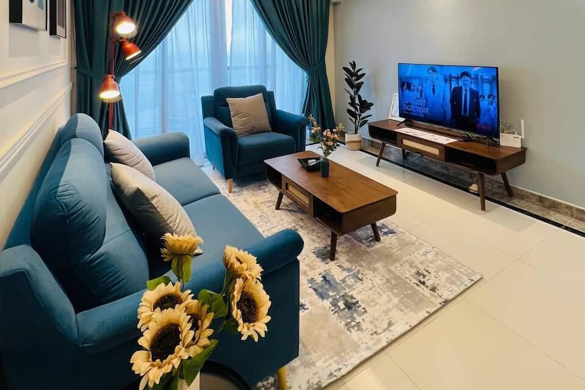 A modern living room with a sofa, a coffee table, a TV, and a ceiling fan.