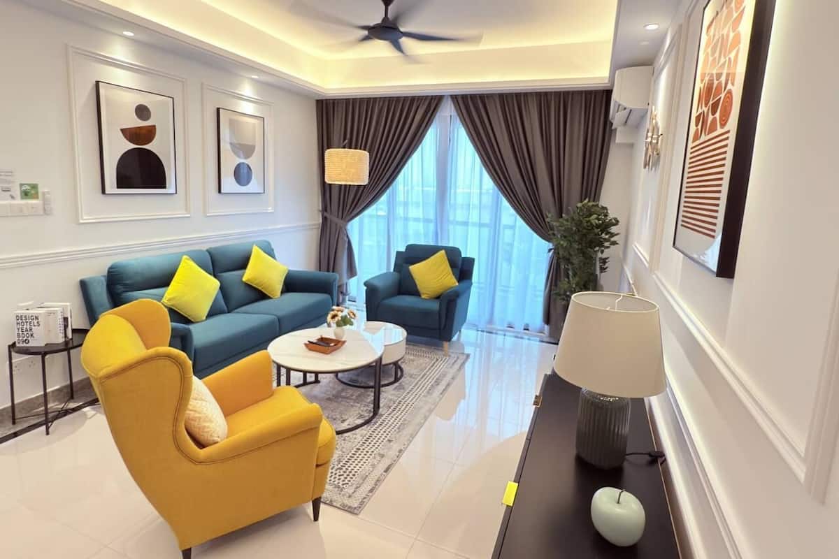 A modern living room with a blue sofa, yellow armchair, and a white coffee table.