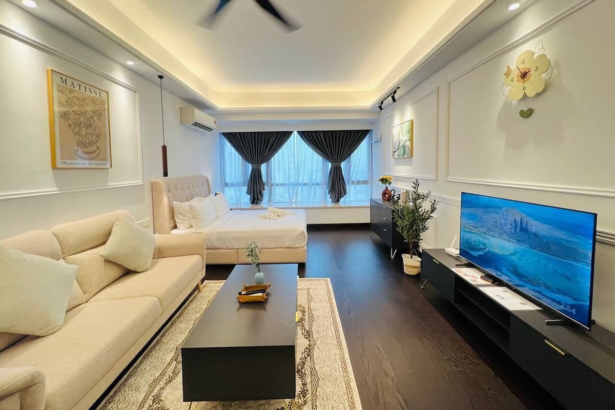 A modern living room with a sofa, a coffee table, a TV, and a ceiling fan.