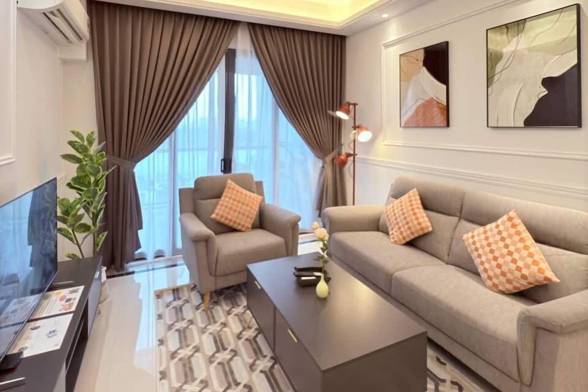 A modern living room with a ceiling fan, two sofas with checkered cushions, a coffee table, and a TV on a stand.