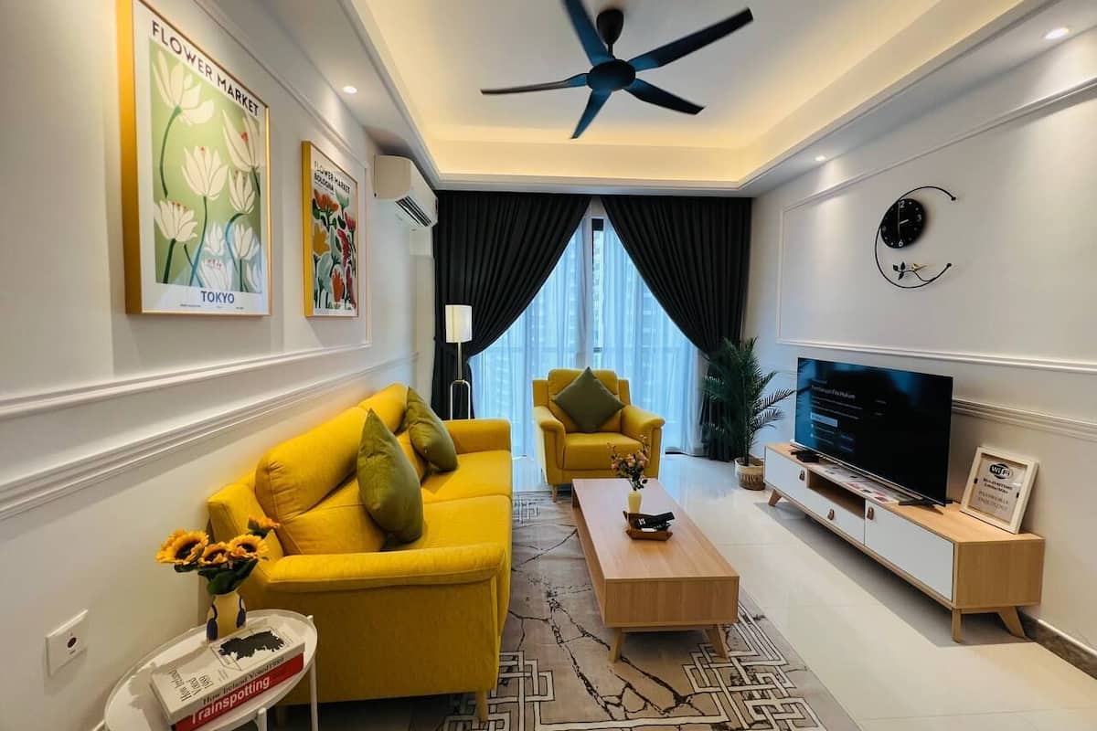 A modern living room with a yellow sofa, a wooden coffee table, a TV on a wooden stand, and a ceiling fan.