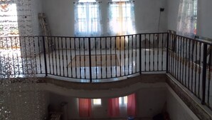 Une chambre avec un balcon, des fenêtres en arc de cercle et une vue sur l’extérieur.