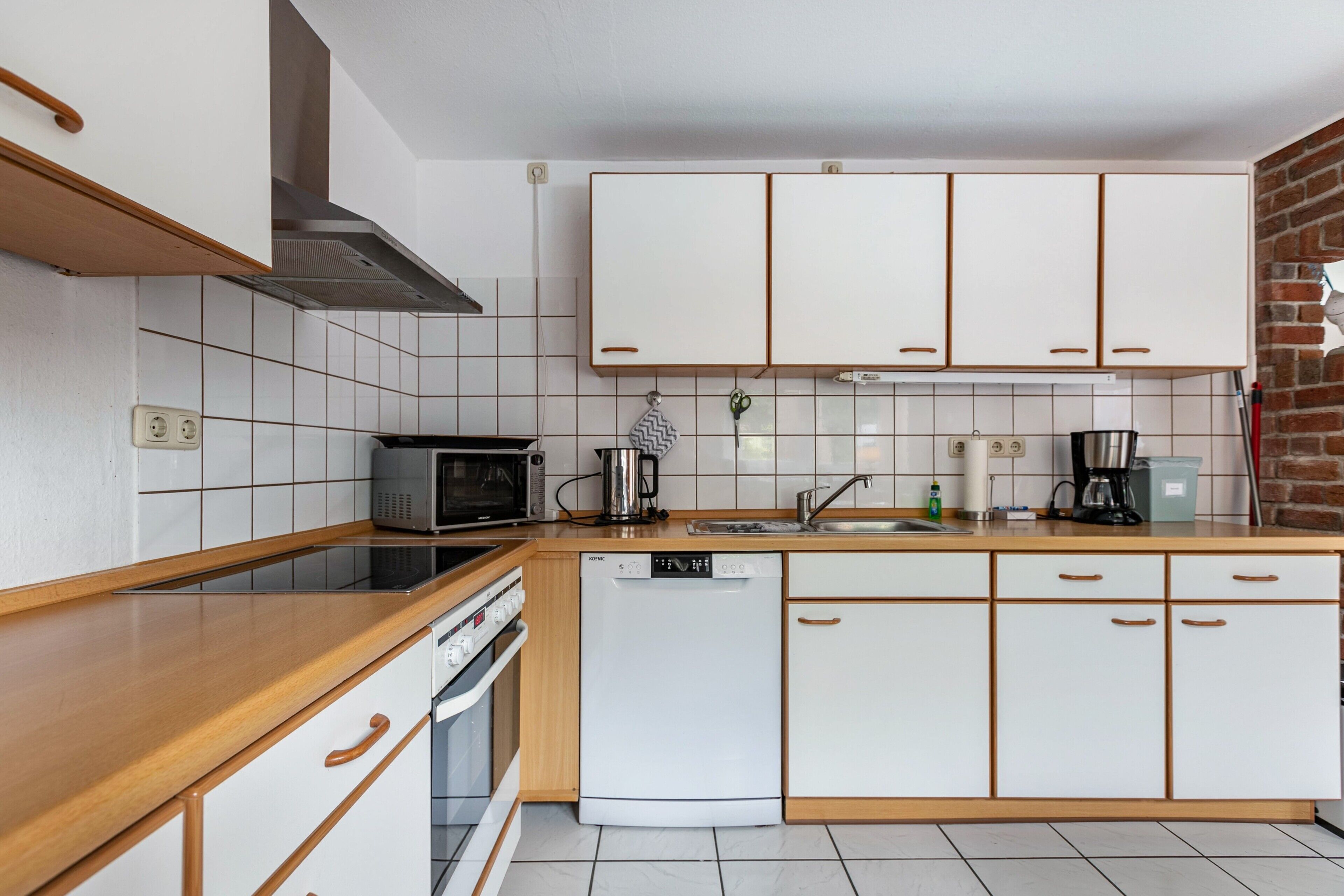 A kitchen with white cabinets, a microwave, a dishwasher, and a stove.