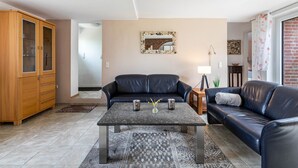 A living room with a sofa, coffee table, and cabinet.