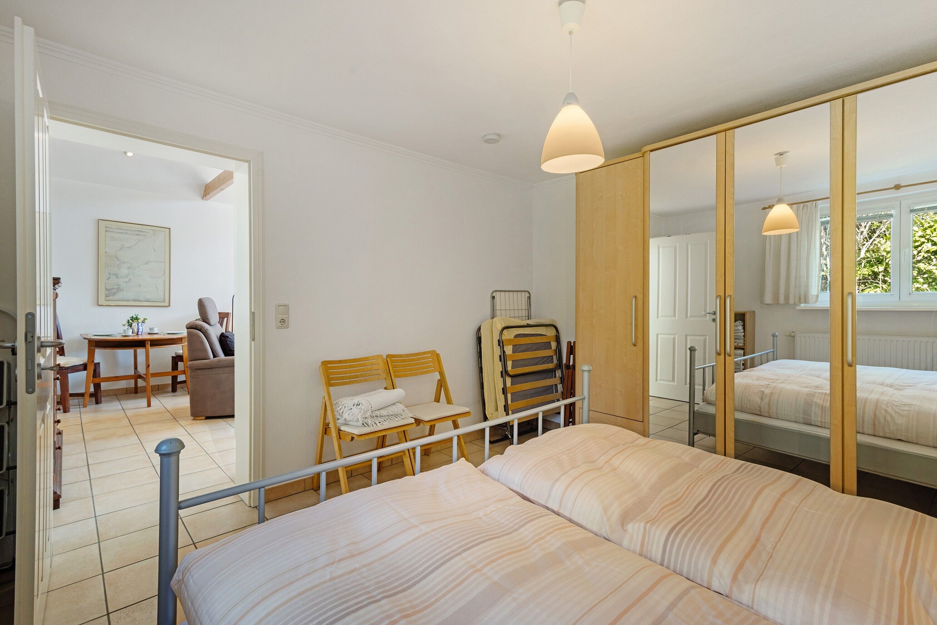 Ein Schlafzimmer mit Bett, Schrank und Schreibtisch mit Stuhl und Tisch.