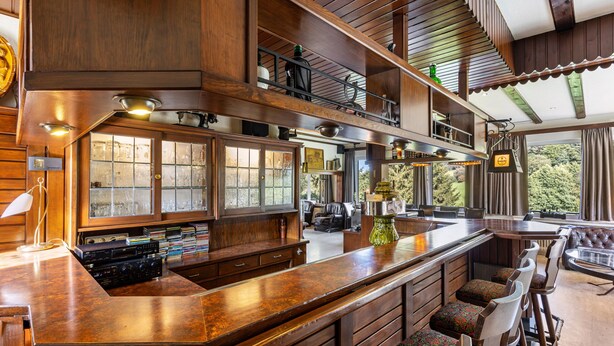 A spacious kitchen with a large island, wooden cabinetry, and a view of the outdoors.