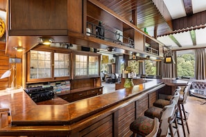 Una cocina amplia con una isla grande, armarios de madera y vistas al exterior.