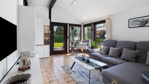 A modern living room with a sofa, coffee table, and a flat-screen TV.