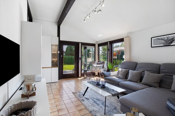 A modern living room with a sofa, coffee table, and a flat-screen TV.