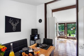 Una cocina moderna con zona de comedor, una cafetera y un reloj en la pared.